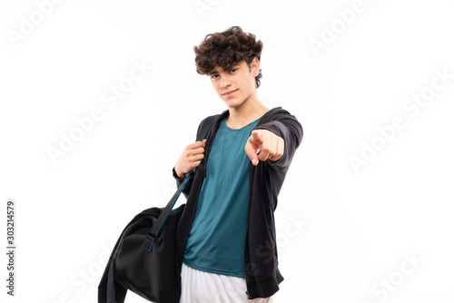 Sport man over isolated white background points finger at you with a confident expression