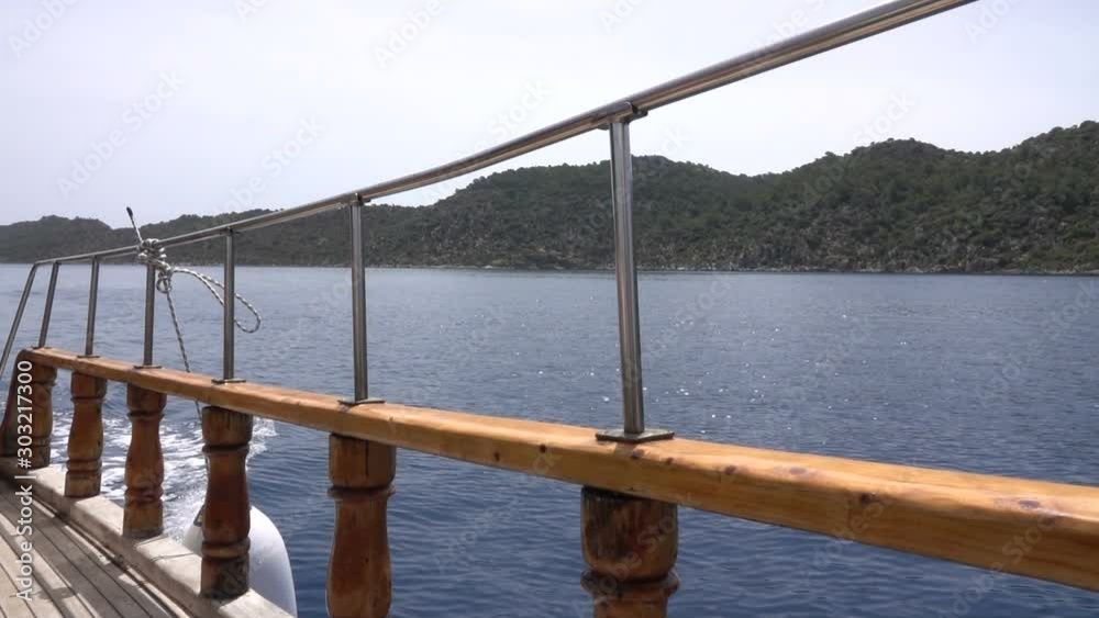 View through railing of cruise ship on misty but sunny day at sea ...