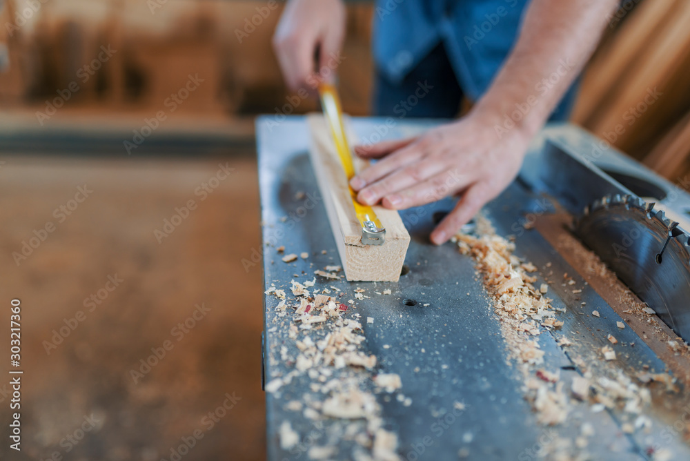 Carpenter with ruler measuring wood plank at workshop Carpenter with ruler measuring wood plank at workshop
