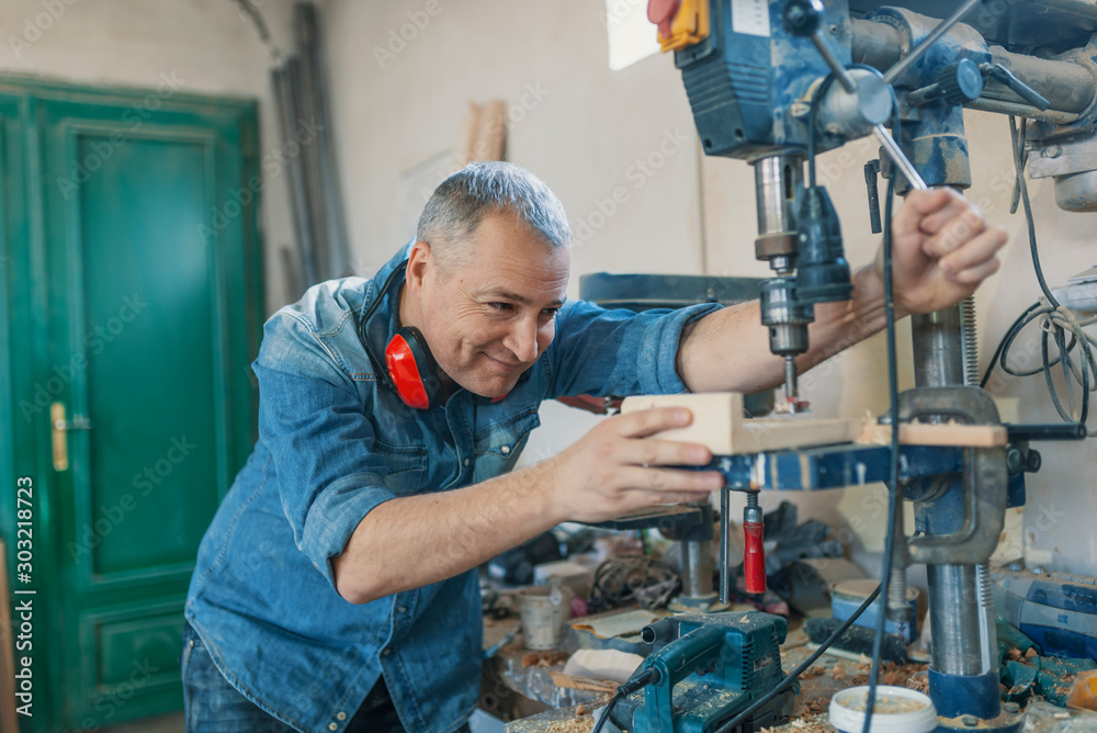 man engineer stand near saw machine to make furniture at carpenters workshop. Handmade business at small furniture factory. man working with machine inside workshop man engineer stand near saw machine to make furniture at carpenters workshop. Handmade business at small furniture factory. man working with machine inside workshop
