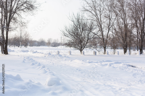 Winter poorly cleared road. Road in the countryside strewn with snow. Winter landscape with snowdrifts