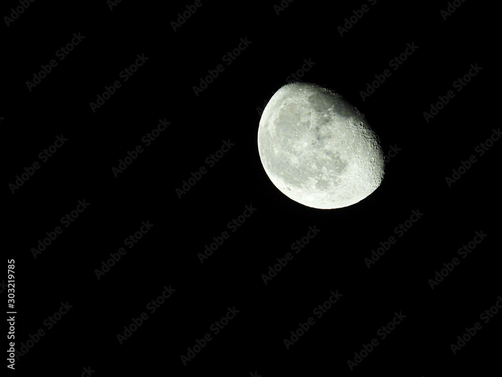 a close-up of the waning three-quarter moon in the starry night sky a close-up of the waning three-quarter moon in the starry night sky