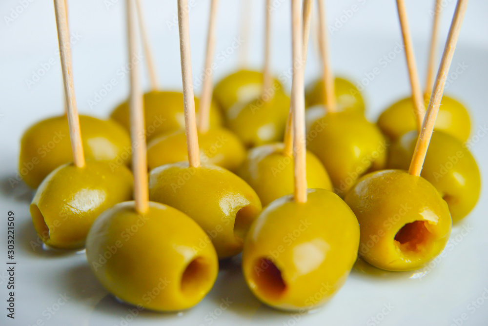 Olive con stuzzicadenti su piatto bianco, aperitivo Olive con stuzzicadenti su piatto bianco, aperitivo