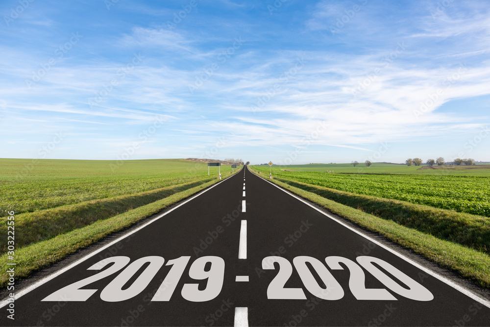 Empty road surrounded by green field and 2019-2020 written