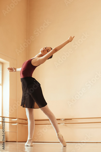 Teenage ballerina dancing at ballet studio.