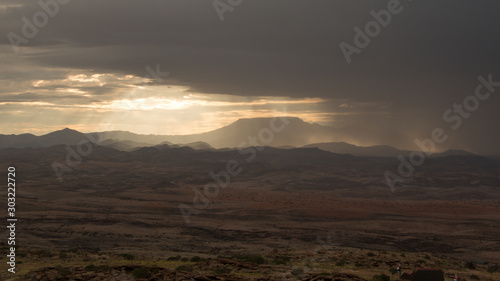Sonnenstrahlen fallen durch die Wolkendecke und erleuchten die Namibischen Berge im Guab Valley