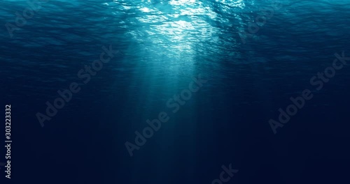 seamless loop of deep blue ocean waves from underwater background, light rays shining through photo