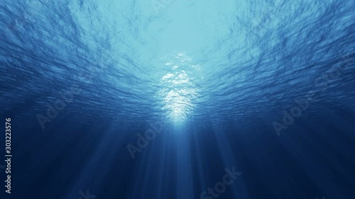 Underwater ocean waves deep blue ripple and flow with light rays. 4K seamless loop photo