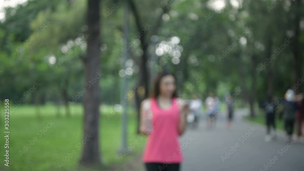 Exercise concepts. Young athletes are drinking and playing mobile in the park. 4k Resolution. Exercise concepts. Young athletes are drinking and playing mobile in the park. 4k Resolution.