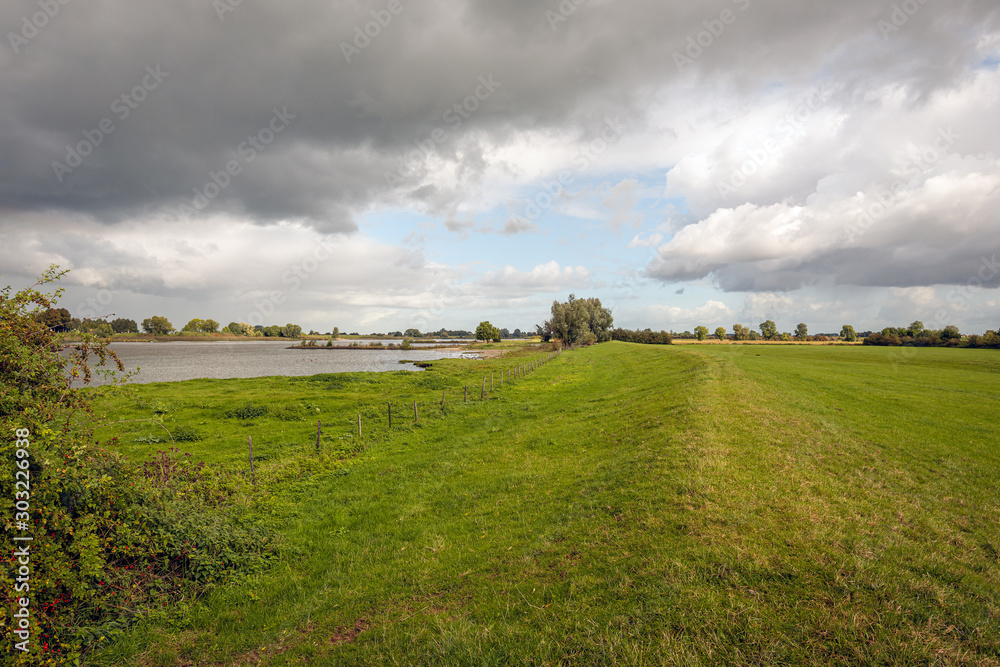 Obraz premium Dark clouds above a wide Dutch river