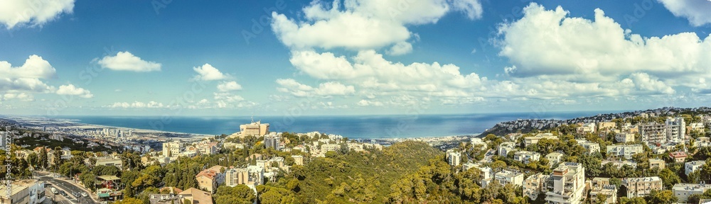 Panoramic views of a residential neighborhood, vegetation, clear sky and open sea views.