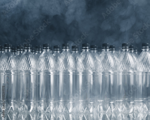 empty plastic bottles on black background with smoke  pollution concept