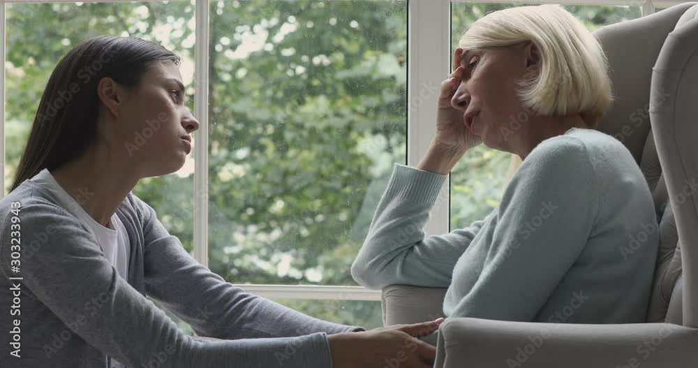 Young adult daughter apologize talk comfort sad crying old mother Young adult daughter apologize talk comfort sad crying old mother