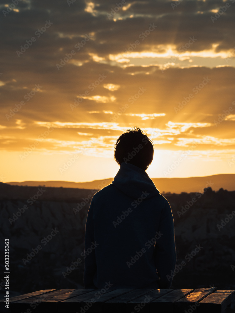 silhouette of man at sunset in sun rays