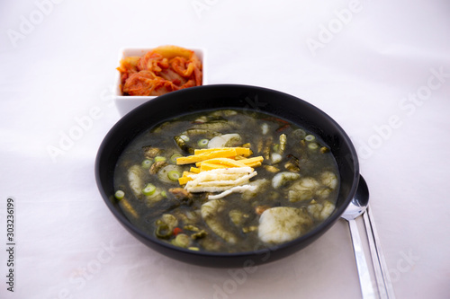 Korean Rice cake Seaweed Fulvescens Soup with oyster which is called Maesaeng-i Tteoggug and kimchi photo