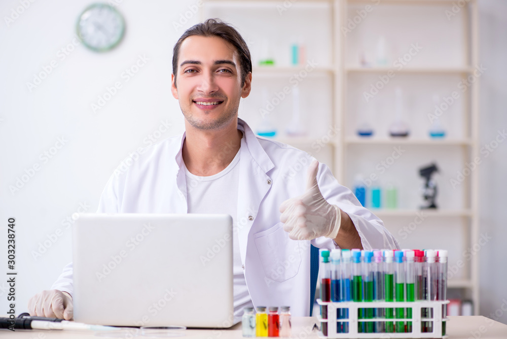 Young male chemist working in the lab Young male chemist working in the lab