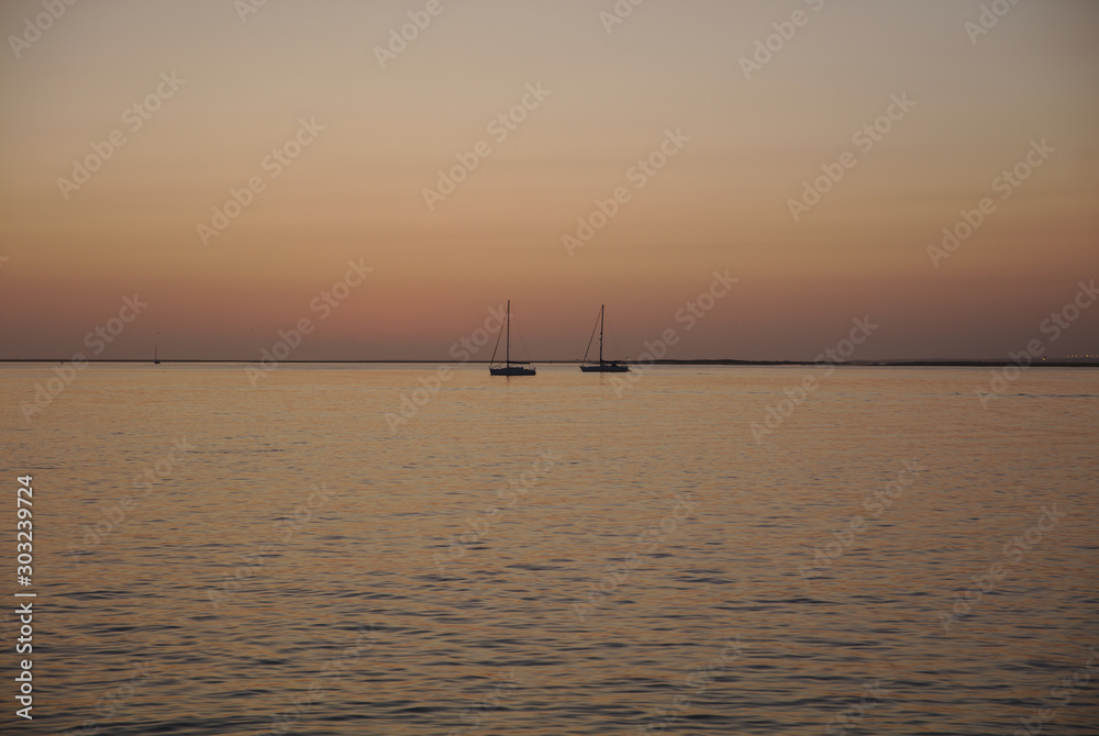 NB__8747 Sunset with anchored sailboats off Ilha Culatra Portugal