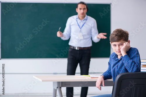 Young male teacher and boy in the classroom