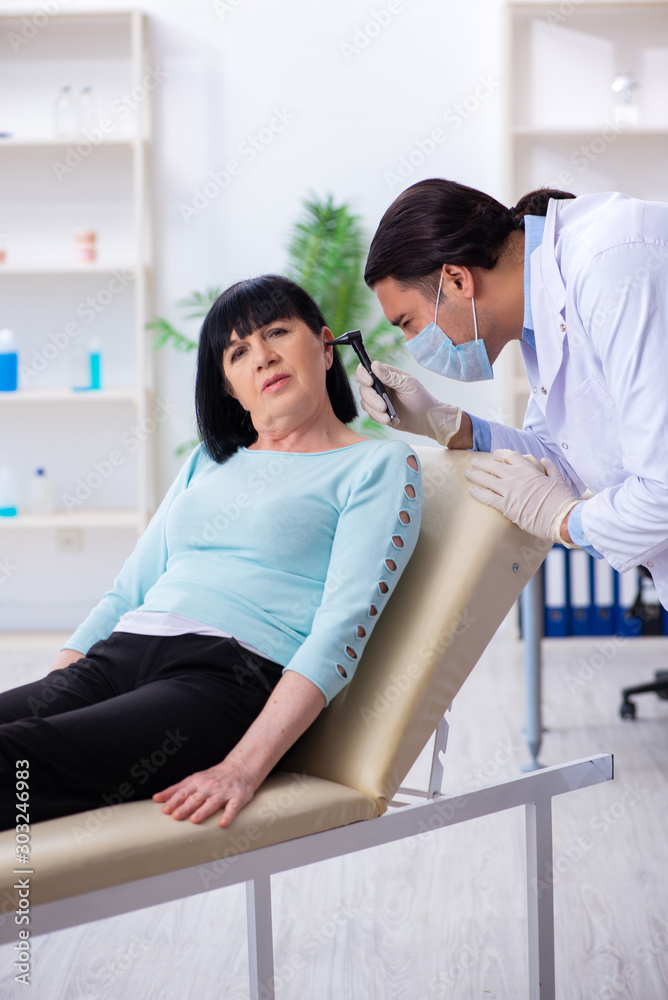 Old woman visiting young doctor laryngologist