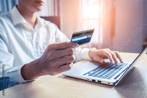 Foto Young man use credit card for shopping payment online on laptop computer application or website