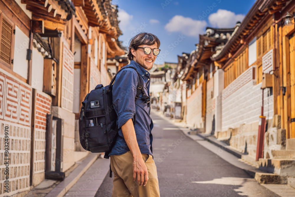 Young man tourist in Bukchon Hanok Village is one of the famous place for Korean traditional houses have been preserved. Travel to Korea Concept Young man tourist in Bukchon Hanok Village is one of the famous place for Korean traditional houses have been preserved. Travel to Korea Concept