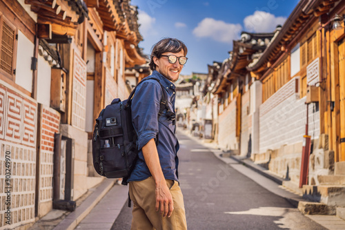 Young man tourist in Bukchon Hanok Village is one of the famous place for Korean traditional houses have been preserved. Travel to Korea Concept © galitskaya
