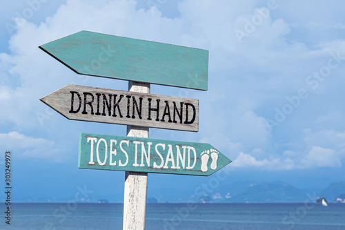 Wooden sign board on the beach and blue sky with sea background.