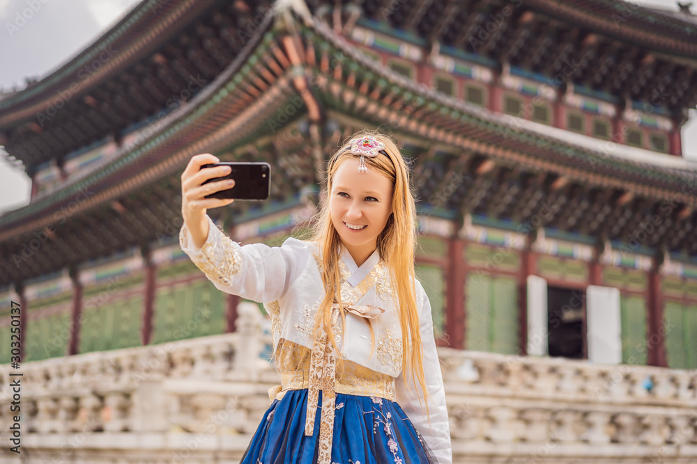Fotografie Young caucasian female tourist in hanbok national korean dress at Korean palace
