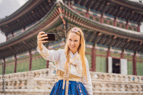 Photography Young caucasian female tourist in hanbok national korean dress at Korean palace