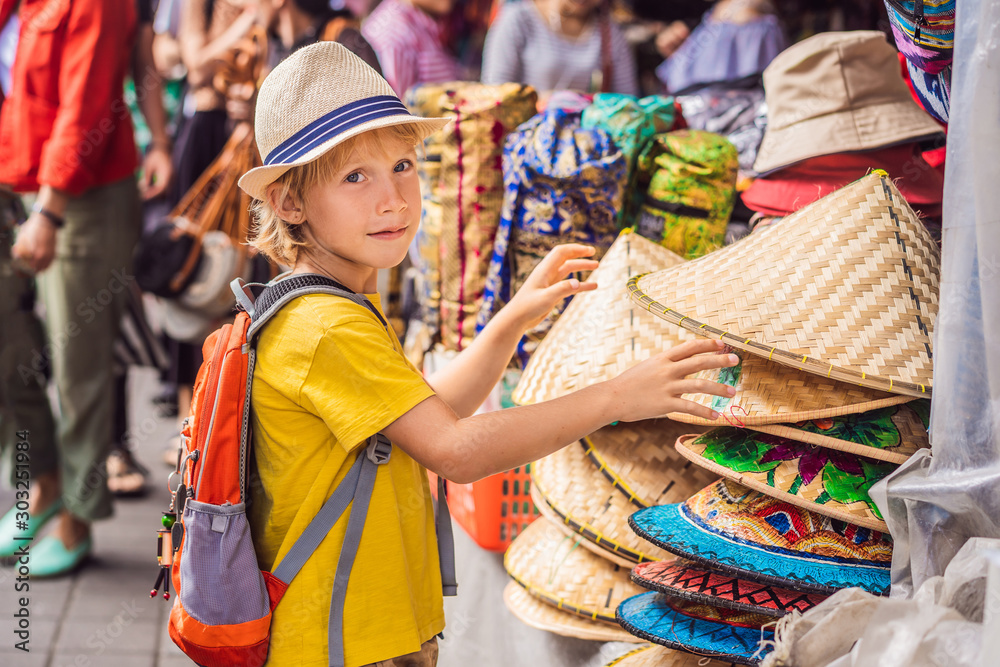 Boy at a market in Ubud, Bali. Typical souvenir shop selling souvenirs and handicrafts of Bali at the famous Ubud Market, Indonesia. Balinese market. Souvenirs of wood and crafts of local residents