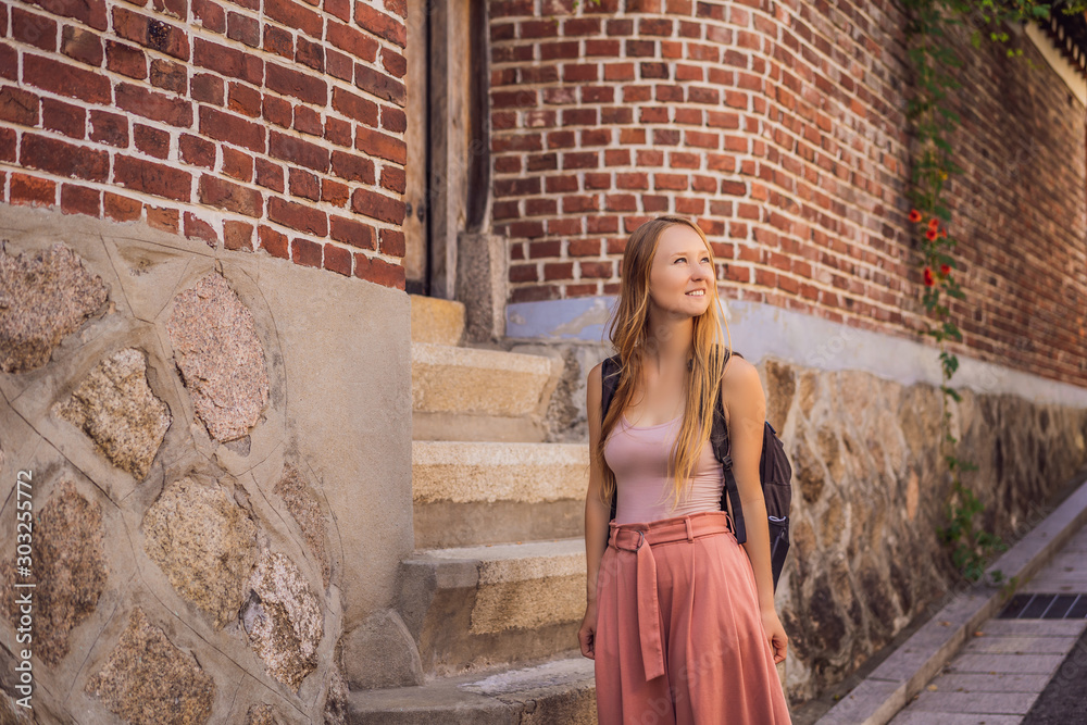 Young woman tourist in Bukchon Hanok Village is one of the famous place for Korean traditional houses have been preserved. Travel to Korea Concept Young woman tourist in Bukchon Hanok Village is one of the famous place for Korean traditional houses have been preserved. Travel to Korea Concept
