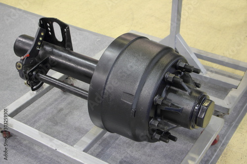 Obraz na płótnie New semi trailer axle with brake drum on stand close up, truck transmission repair w salonie