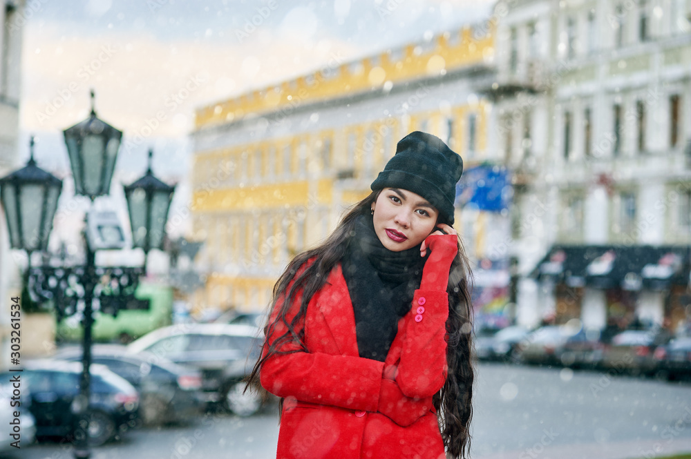 Girl in winter city . Young woman on a walk on a winter day in a European city .