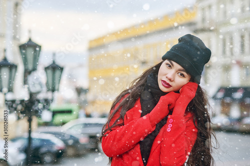 Girl in winter city . Young woman on a walk on a winter day in a European city .