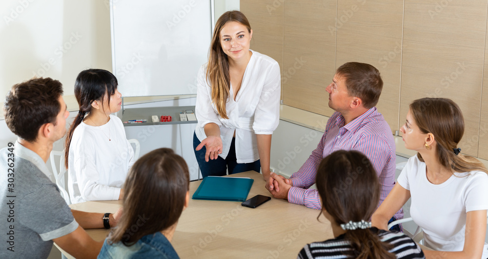 Woman reading out report to colleagues