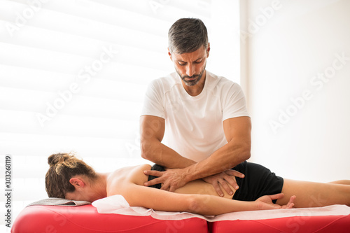 Osteopath doing a liliocostalis muscle treatment