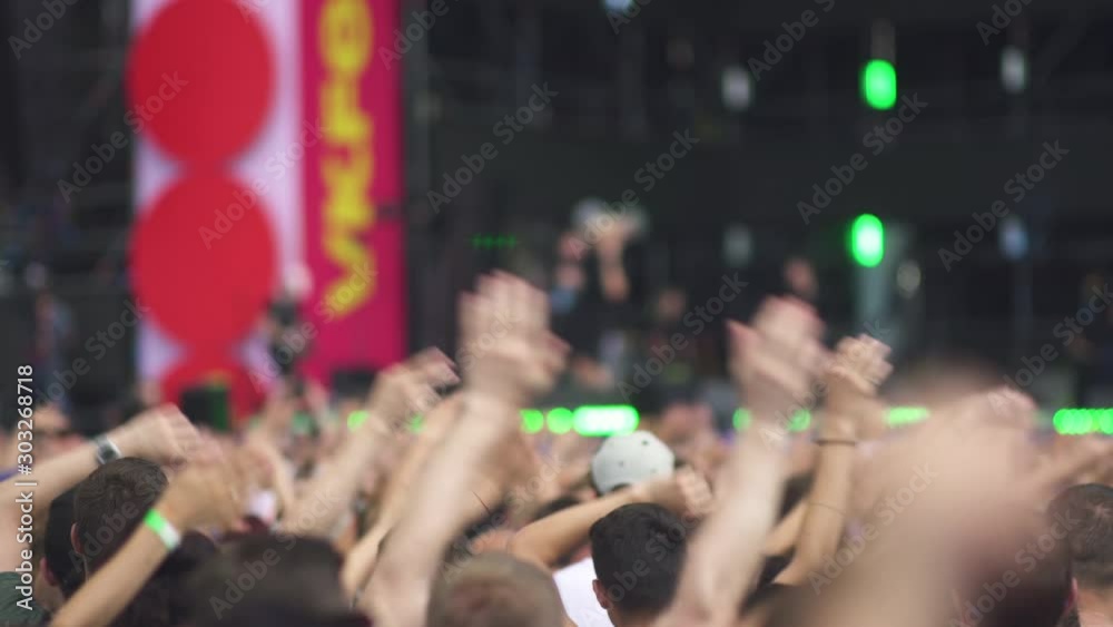 Night rock concert front row crowd cheering hands in air. Series of real time close up shots from a night rock concert. People hands up in unison against the strobing stage lights. Night rock concert front row crowd cheering hands in air. Series of real time close up shots from a night rock concert. People hands up in unison against the strobing stage lights.
