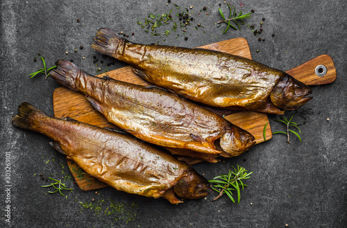 Smoked fish with spices on dark background