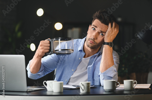 Tired man drinking coffee a...
