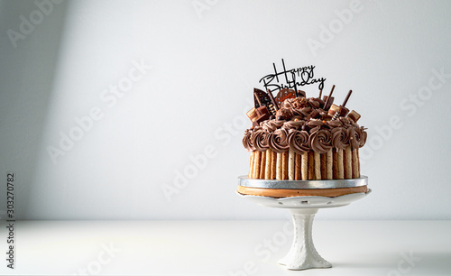 Happy birthday chocolate cake with candles and Happy birthday tag on white table, food concept background with copy space