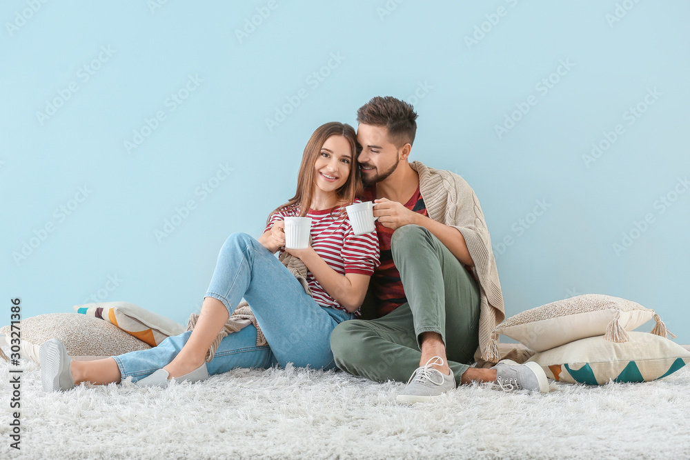 Portrait of happy young couple drinking tea indoors