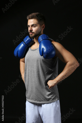 Sporty male boxer on dark b...
