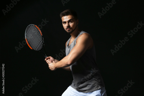 Male tennis player on dark ...