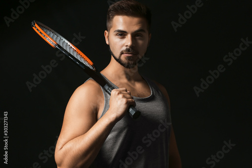Male tennis player on dark ...