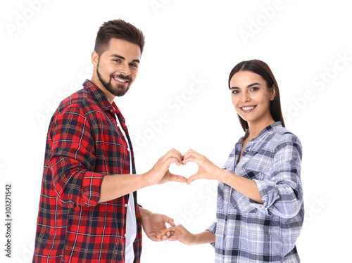 Portrait of beautiful young couple holding hands in shape of heart on white background