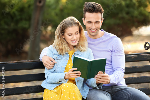 Cute young couple with book...