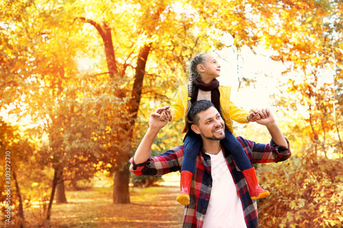 Happy father and daughter in autumn park