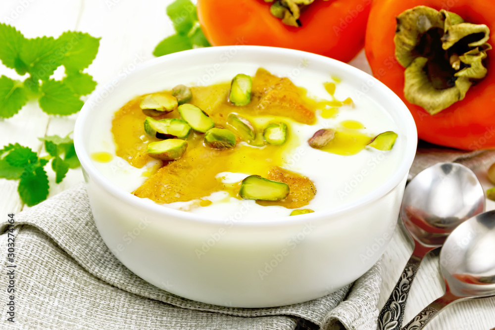 Dessert of yogurt and persimmon in bowl on wooden board Dessert of yogurt and persimmon in bowl on wooden board
