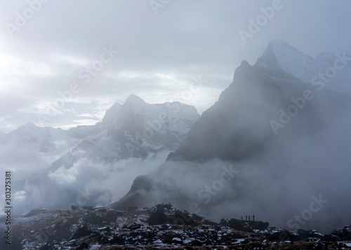 Three trekkers are doing their acclimatization hike in cloudy weather photo