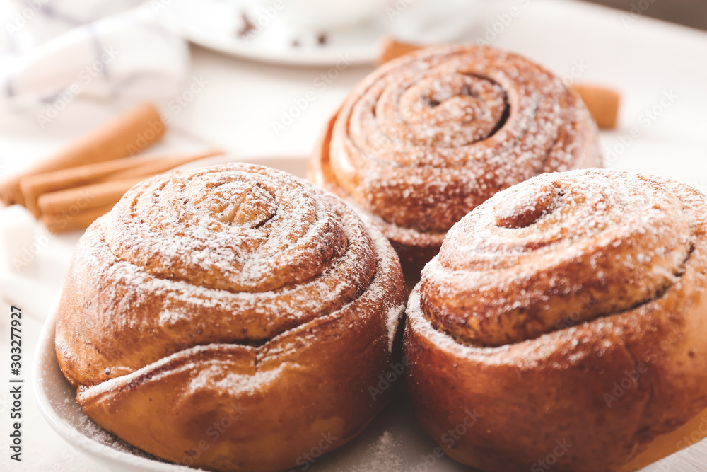 Plate with tasty cinnamon buns on table, closeup Plate with tasty cinnamon buns on table, closeup